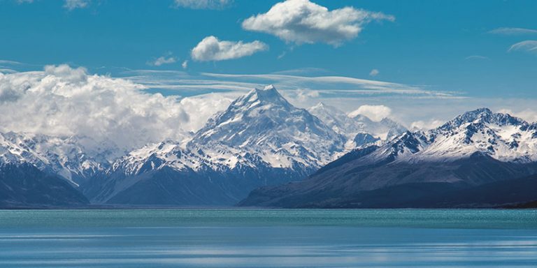 Snow covered peak of Mt Cook with lake in the foreground