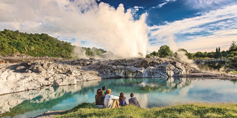 group watching geysers in Rotorua geothermal valley